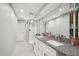 Sleek bathroom with double sinks, black-and-white tile floors, and glass-enclosed shower at 5172 S Cody Ct, Littleton, CO 80123