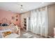 Charming bedroom with pink accent wall, whimsical decor, and bright natural light at 5172 S Cody Ct, Littleton, CO 80123