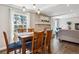 Dining area with large windows, wood table, comfortable seating, and open view to living area at 5172 S Cody Ct, Littleton, CO 80123