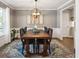 Elegant dining room with a large wooden table, stylish chandelier, and beautiful artwork on the wall at 5172 S Cody Ct, Littleton, CO 80123