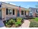 Charming brick home with inviting front porch, well-manicured landscaping, and American flag at 5172 S Cody Ct, Littleton, CO 80123