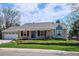 This charming home features a well-manicured lawn and inviting front porch with brick and colorful plants at 5172 S Cody Ct, Littleton, CO 80123