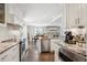 Modern kitchen featuring white cabinetry, granite countertops, stainless steel appliances, and an open layout at 5172 S Cody Ct, Littleton, CO 80123