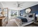 Serene main bedroom with a large window, plush bedding, and stylish blue accent wall at 5172 S Cody Ct, Littleton, CO 80123