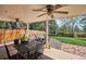 Covered patio with outdoor seating, ceiling fans, and a beautifully landscaped backyard at 5172 S Cody Ct, Littleton, CO 80123