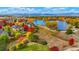 Stunning aerial view of home near a lake, showcasing colorful fall foliage and mountain backdrop at 1647 Harris Ct, Erie, CO 80516