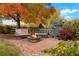 Cozy backyard patio with stone pavers, comfortable seating around a fire pit, and lush landscaping at 1647 Harris Ct, Erie, CO 80516