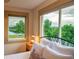 Peaceful bedroom featuring large windows with beautiful views of the water, greenery, and distant mountains at 1647 Harris Ct, Erie, CO 80516