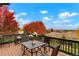 Relaxing deck area with outdoor dining set and grill, showcasing autumn foliage and views of the surrounding landscape at 1647 Harris Ct, Erie, CO 80516