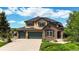 Beautiful two-story home featuring manicured lawn, three-car garage, stone accents, and lush landscaping at 1647 Harris Ct, Erie, CO 80516