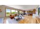 Open-concept living room featuring hardwood floors, a large window with natural light, and access to the kitchen at 1647 Harris Ct, Erie, CO 80516