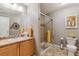 Bathroom with vanity, mirrored cabinet, and a glass shower enclosure with neutral tones and yellow accents at 10056 W Unser Dr # 102, Littleton, CO 80127