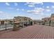Large deck overlooking townhouses with stone accents on the front and black railings offering scenic views at 10056 W Unser Dr # 102, Littleton, CO 80127