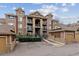 Multi-story condo building with brick and siding exterior, private balconies, and convenient parking spaces at 10056 W Unser Dr # 102, Littleton, CO 80127