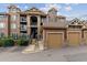 Multi-story condo building with brick and siding exterior, private balconies, and garage parking at 10056 W Unser Dr # 102, Littleton, CO 80127