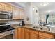 Kitchen showcasing stainless steel oven, granite counters, and access to living area at 10056 W Unser Dr # 102, Littleton, CO 80127