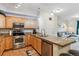 Bright kitchen features granite countertops, stainless appliances, and convenient breakfast bar at 10056 W Unser Dr # 102, Littleton, CO 80127