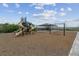 Community playground with swings, slides, and a shaded picnic area surrounded by open fields at 10056 W Unser Dr # 102, Littleton, CO 80127