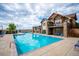 Large community pool next to a clubhouse with a spa and stone pillars on a sunny day at 10056 W Unser Dr # 102, Littleton, CO 80127