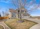 Two-story stucco home with a three-car garage and manicured lawn, complemented by a stone-lined flower bed at 14711 Detroit Way, Thornton, CO 80602