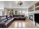 Inviting living room with hardwood floors, a cozy fireplace, and a comfortable leather sectional sofa at 14711 Detroit Way, Thornton, CO 80602