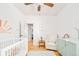 Bedroom room with hardwood floors, ceiling fan, rocking chair, crib, and mint green dresser at 277 S Gilpin St, Denver, CO 80209