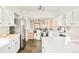 Open kitchen with stainless steel appliances, white cabinets, and view into living area at 277 S Gilpin St, Denver, CO 80209