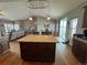 An open-concept kitchen featuring a center island with granite countertops and wooden cabinets at 14545 Barksdaly Way, Keenesburg, CO 80643
