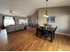 Inviting living area with vaulted ceilings, hardwood floors, and an adjacent dining space with a large dining table at 14545 Barksdaly Way, Keenesburg, CO 80643