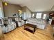 A cozy living room with plush reclining seating, wooden floors and lots of space at 14545 Barksdaly Way, Keenesburg, CO 80643