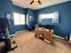 Home office with a solid wood desk, ceiling fan, exercise bike and plenty of natural light at 14545 Barksdaly Way, Keenesburg, CO 80643