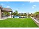 Backyard oasis with a pool, spa, covered patio, and lush landscaping at 3749 White Bay Dr, Highlands Ranch, CO 80126