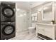 Modern bathroom with stacked laundry units, marble shower, and vanity at 3749 White Bay Dr, Highlands Ranch, CO 80126