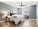 A cozy bedroom with a ceiling fan, window, and hardwood floors at 3749 White Bay Dr, Highlands Ranch, CO 80126