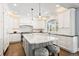 Bright, modern kitchen with white cabinets, a marble island, and stainless steel appliances at 3749 White Bay Dr, Highlands Ranch, CO 80126