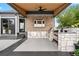Well-equipped outdoor kitchen with stone counters, stainless appliances, and a ceiling fan for comfort at 3749 White Bay Dr, Highlands Ranch, CO 80126