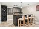 Wet bar featuring dark cabinetry, a wine rack, and seating for three at 3749 White Bay Dr, Highlands Ranch, CO 80126