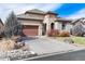 Attractive home featuring a stone facade, a large driveway, a tile roof, and manicured landscaping at 16 Willowcroft Dr, Littleton, CO 80123
