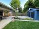 The backyard is well landscaped with a blue garage and lovely patio area at 1335 S Holly St, Denver, CO 80222