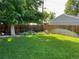 View of the well-manicured backyard with mature trees and a beautiful lawn at 1335 S Holly St, Denver, CO 80222