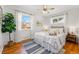 Charming bedroom featuring hardwood floors, a ceiling fan, and large windows at 1335 S Holly St, Denver, CO 80222