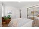This bedroom includes hardwood floors, art, natural light, and a mirrored closet at 1335 S Holly St, Denver, CO 80222