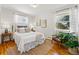 Bright bedroom featuring hardwood floors, neutral walls, and updated windows at 1335 S Holly St, Denver, CO 80222