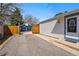 View of a home's driveway leading to a detached garage with a basketball hoop and fenced yard at 1335 S Holly St, Denver, CO 80222