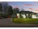 Charming home with a well-manicured lawn at dusk at 1335 S Holly St, Denver, CO 80222
