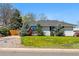 Traditional single-story home featuring a lush green lawn and established trees at 1335 S Holly St, Denver, CO 80222