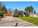 Single-story home with a well-manicured lawn and mature landscaping, with a driveway at 1335 S Holly St, Denver, CO 80222