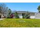 Charming single-story home with a well-manicured front lawn and mature landscaping at 1335 S Holly St, Denver, CO 80222