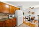 Cozy kitchen features wood cabinets, stone backsplash, and bright adjacent dining area at 1335 S Holly St, Denver, CO 80222
