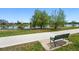 Park bench seating beside a pond, with trees around the water's edge at 1335 S Holly St, Denver, CO 80222